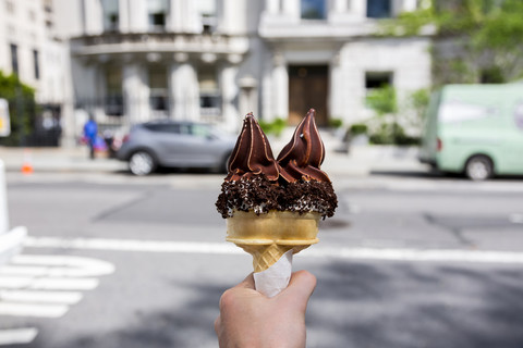 USA, New York City, Hand mit doppeltem Schokoladeneis, lizenzfreies Stockfoto