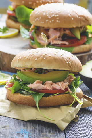 Lachsburger mit Avocado, Rucola und Joghurtsauce, lizenzfreies Stockfoto