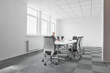 Businessman using laptop in conference room - RHF02014