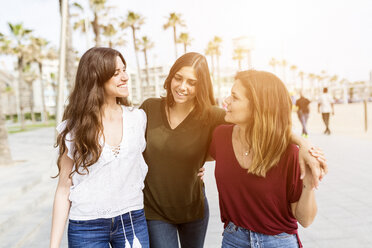 Three happy looking women walking on street wearing fashionable