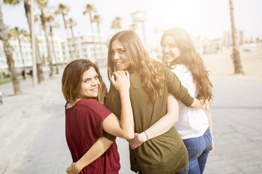 Three happy female friends strolling on the boardwalk - GIOF03004