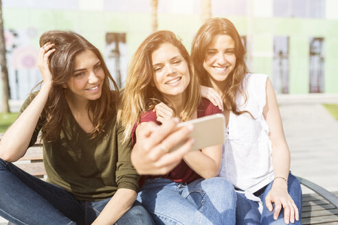 Drei glückliche Freundinnen machen ein Selfie im Freien - GIOF03005
