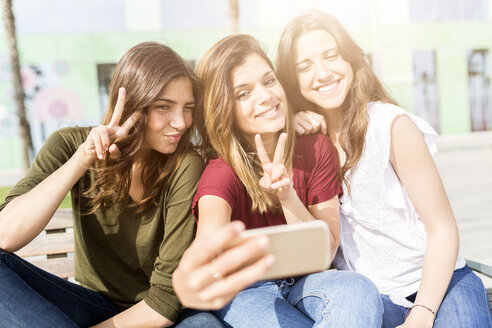 Drei glückliche Freundinnen machen ein Selfie im Freien - GIOF03006