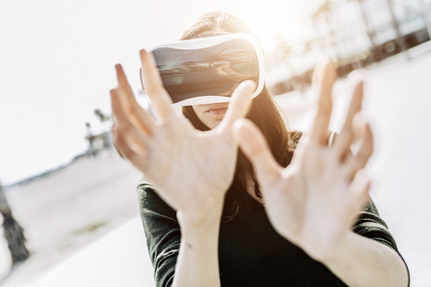 Junge Frau trägt VR-Brille im Freien, lizenzfreies Stockfoto
