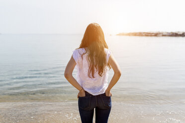 Rückansicht einer jungen Frau, die am Meer steht - GIOF03031