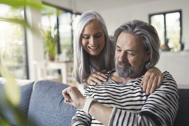 Senior couple looking at smartwatch - SBOF00467