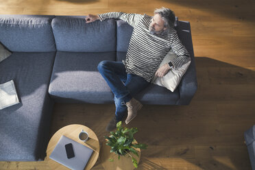Senior man sitting on couch, relaxing and thinking - SBOF00468