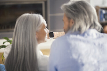 Senior couple looking at smartwatch - SBOF00482