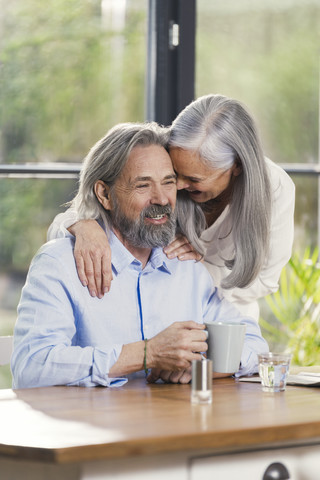 Glückliches älteres Paar trinkt zu Hause Kaffee, lizenzfreies Stockfoto