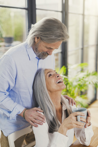 Glückliches älteres Paar trinkt zu Hause Kaffee, lizenzfreies Stockfoto