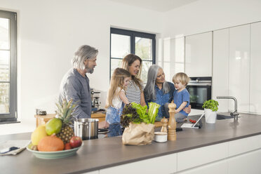 Grandparents with grandchildren and their mother standing in kitchen - SBOF00505