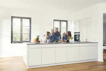 Glückliche Familie mit Großeltern und Kindern, die in der Küche stehen - SBOF00508