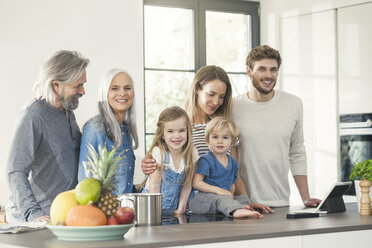Glückliche Familie mit Großeltern und Kindern, die in der Küche stehen - SBOF00510