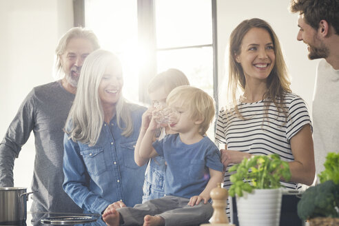 Happy family with grandparents and children standing in the kitchen - SBOF00511