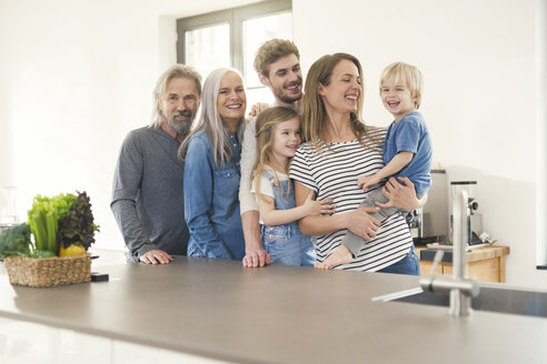 Glückliche Familie mit Großeltern und Kindern, die in der Küche stehen - SBOF00517