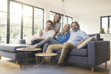 Senior couple with family sitting on couch - SBOF00520