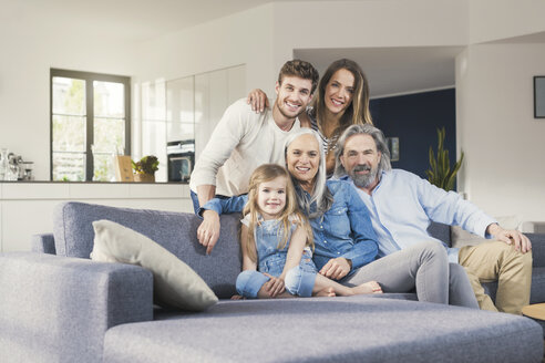 Großfamilie sitzt glücklich lächelnd auf der Couch - SBOF00531