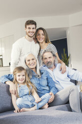 Großfamilie sitzt glücklich lächelnd auf der Couch - SBOF00532