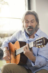 Senior man playing passionately his guitar - SBOF00548