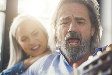 Senior playing guitar and singing loud for his wife - SBOF00550