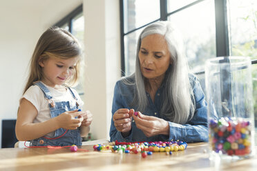 Grandmother and granddaughter threading beads - SBOF00574