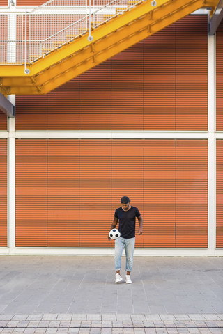 Junger Mann spielt mit Fußball, lizenzfreies Stockfoto