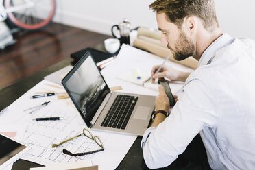 Architect working on laptop in his office - GIOF03057