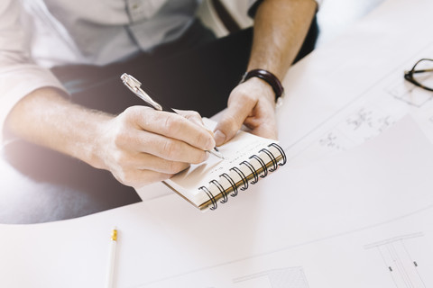 Architect taking notes at desk stock photo