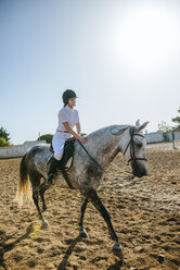 Junge Frau reitet auf einem Pferd - KIJF01711