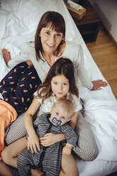 Glückliche Mutter im Bett mit ihren drei Kindern - MFF03699
