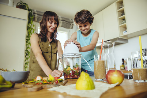 Sohn mischt Smoothie mit Mutter, lizenzfreies Stockfoto