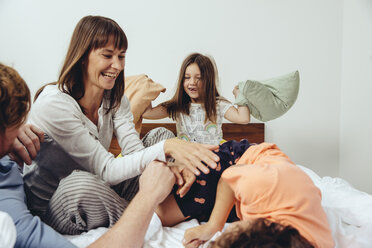 Eltern und ihre Kinder bei einer Kissenschlacht im Bett - MFF03704