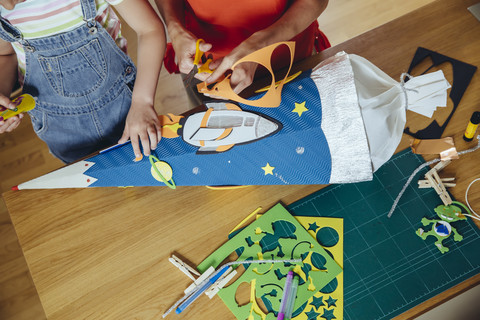 Mother and daughter creating her space themed school cone at home stock photo