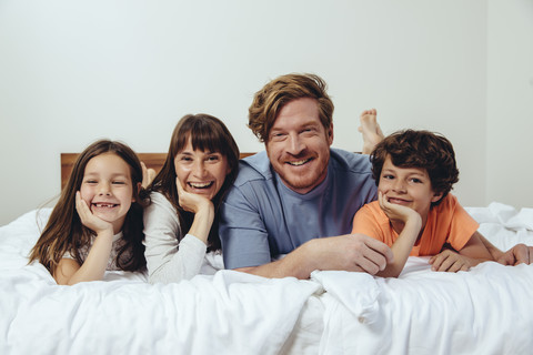 Portrait of parents and their children in bed stock photo