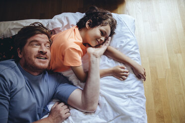 Father and son relaxing on bed - MFF03725