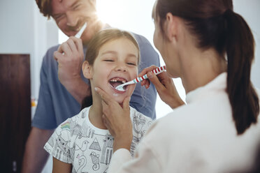 Mother brushing daughter’s teeth in bathroom - MFF03732