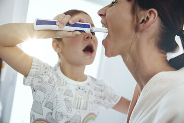 Daughter brushing her mother’s teeth in bathroom - MFF03737