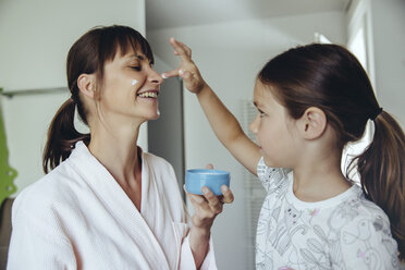 Tochter trägt Gesichtscreme auf das Gesicht der Mutter auf - MFF03738