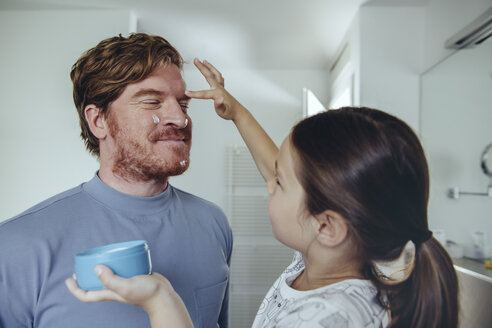 Tochter trägt Gesichtscreme auf das Gesicht des Vaters auf - MFF03741