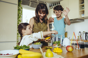 Mutter und Kinder geben Obst in einen Smoothie-Mixer - MFF03751