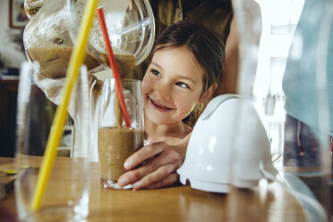 Mädchen gießt Smoothie mit Hilfe der Mutter in ein Glas - MFF03758