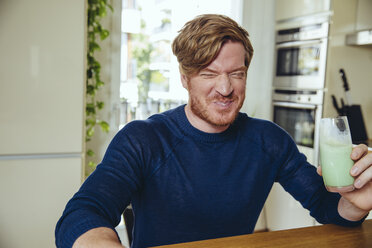 Man making a funny face after drinking a healthy drink - MFF03767