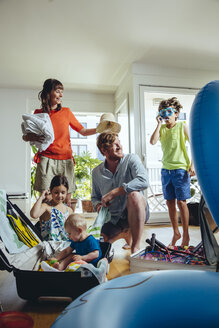 Happy family of five packing for holiday trip - MFF03778