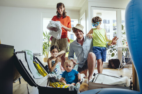 Happy family of five packing for holiday trip - MFF03779