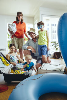 Happy family of five packing for holiday trip - MFF03780