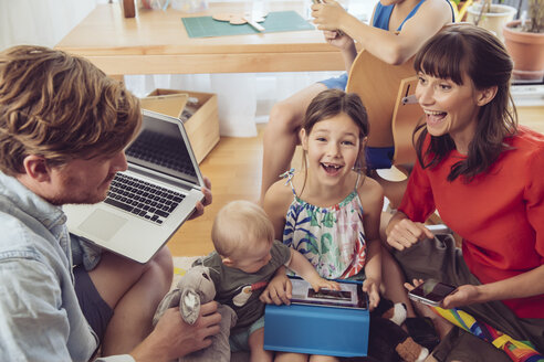 Glückliche, verspielte Familie, die digitale Geräte im Kinderzimmer benutzt - MFF03795