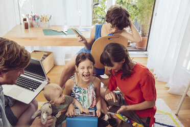 Glückliche, verspielte Familie, die digitale Geräte im Kinderzimmer benutzt - MFF03796