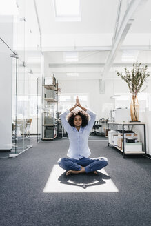 Junge Frau macht Yoga im Büro - KNSF02255