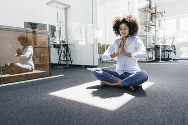 Junge Frau macht Yoga im Büro - KNSF02257