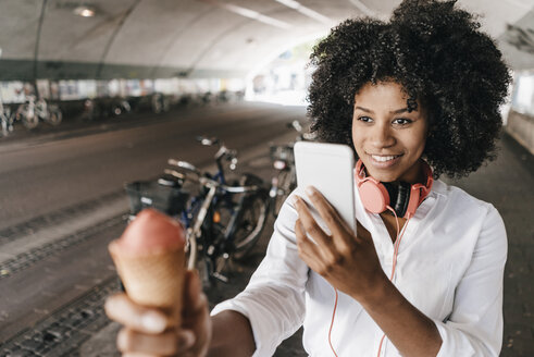 Happy young woman taking cell phone picture of ice cream cone - KNSF02259